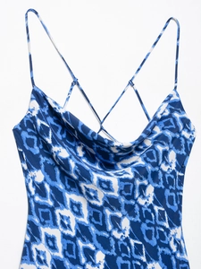 Dettaglio dello scollo a cappuccio e spalline sottili su un abito midi blu geometrico