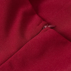 Detail view of high-quality invisible zipper on a red mesh dress with crepe fabric texture