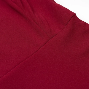 Detailed macro view showing stitching and pleated fabric texture of the burgundy dress