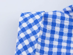 Detailed macro view of the blue and white gingham fabric texture for summer jumpsuits