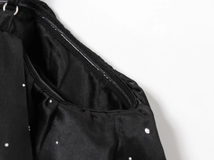 Détail du haut en satin noir montrant des strass et une doublure intérieure en silicone
