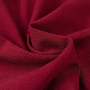 Detailed macro view of dark red mesh fabric with fine grainy texture and soft drape