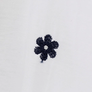 Close-up of dark blue floral embroidery on white poplin cotton spring shirt