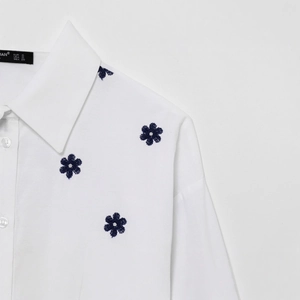 White cotton poplin shirt for women featuring delicate blue floral embroidery and lapel collar