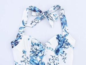 Detailed close-up of blue floral print halter top with delicate neck tie and bow detail