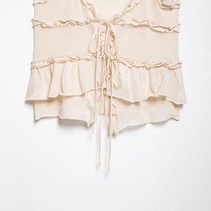 Haut chic en maille beige à volants avec nœuds frontaux et texture douce côtelée