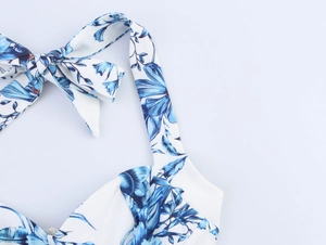 Detail of blue floral halter neck dress with elegant tie-up bow and jacquard print