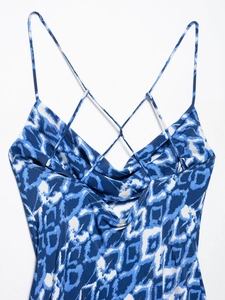 Dettaglio dell'abito con stampa astratta blu e bianca, texture satinata e spalline incrociate
