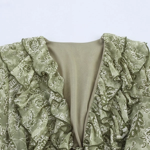 Détail du col en V avec volants superposés sur la robe fleurie en mousseline olive