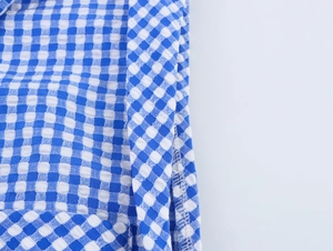 Close-up of blue and white gingham seersucker fabric with neat stitching and texture