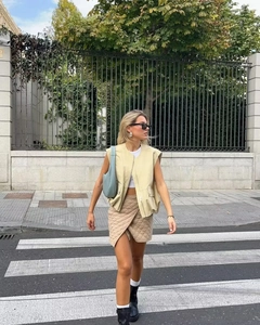 Street style view of women's beige utility vest and quilted wrap skirt with pockets