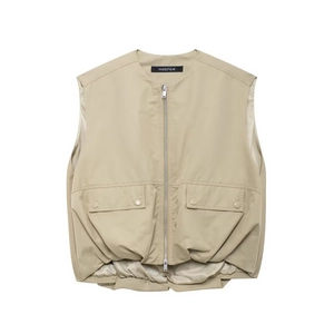 Detail of beige zip-up vest featuring metal zipper and dual snap-button pockets