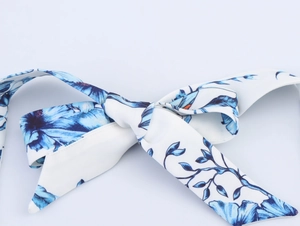 Detailed macro view of the halter neck tie featuring blue floral jacquard print pattern