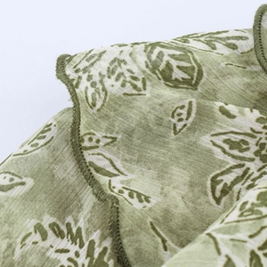 Détail de l'imprimé floral vert sur robe d'été légère avec finitions à volants