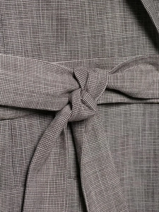 Close-up of the waist tie detail on a taupe houndstooth blazer set for women