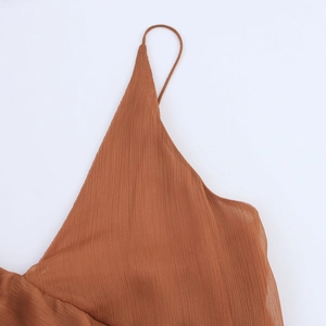 Détail du tissu plissé en mousseline marron caramel avec de fines bretelles et plis