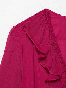 Detail von V-Ausschnitt und Rüschenkanten an diesem sommerlichen Kleid in Hot Pink