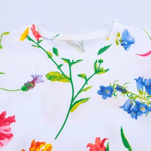 Primer plano del cuello redondo y el estampado floral de colores en la camiseta blanca