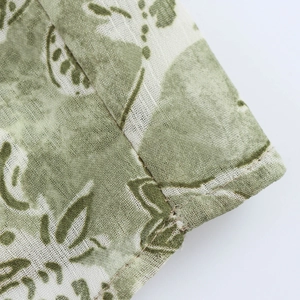 Vue détaillée de l'imprimé botanique vert sur robe en lin avec finitions de couture