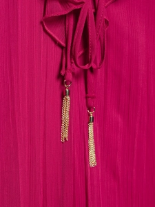 Detailansicht des fuchsiafarbenen Crinkle-Kleids mit Rüschenkragen und goldener Quaste