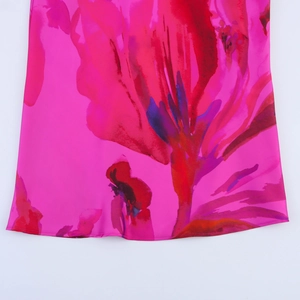 Close-up of bright pink summer dress fabric with bold red and purple abstract floral print