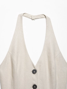 Detail of beige linen vest with deep V-neckline and two dark wooden buttons on front