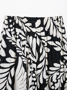 Détail de la taille élastique sur jupe midi avec imprimé floral tropical noir et blanc