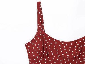 Detail of adjustable straps and pleated chest on a red polka dot camisole dress