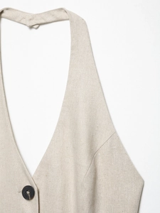 Detail of oatmeal linen vest featuring a deep V-neck, single button and natural fabric texture