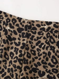 Detailed close-up of leopard print shorts showing waist pleats and twill fabric texture