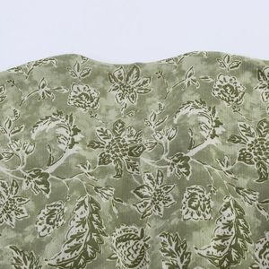 Détail du tissu à imprimé fleuri vert avec vue macro du décolleté et texture de la robe