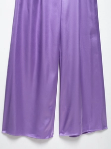 Close-up of smooth purple satin fabric texture with soft silk sheen on wide-leg jumpsuit