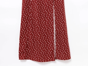 Detailed close-up of a red skirt with white polka dots featuring a side slit design