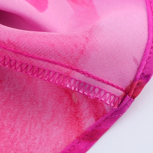 Gros plan détaillé des coutures overlock et de la finition du bord de la robe rose