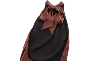 Détail de robe noire élégante avec un grand nœud en satin marron sur l'encolure