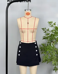 Detail view of black mini skirt with white decorative side buttons and A-line cut