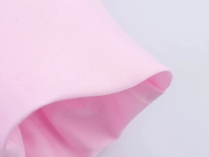 Nahaufnahme der rosa Webstruktur und der ordentlich gefalteten Kante des Kleides