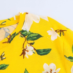 Primer plano del cuello redondo y el estampado floral blanco en el top amarillo de verano