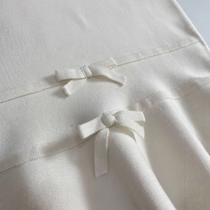 Haut tricoté sans manches crème chic avec nœuds élégants et texture côtelée pour printemps