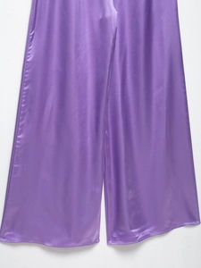 Detail of purple satin wide-leg trousers showing smooth glossy fabric and flowing texture