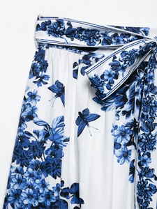 Détail de la jupe midi en satin avec imprimé floral bleu et ceinture nouée à la taille