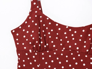 Detailed close-up of dark red polka dot dress featuring ruched chest and spaghetti straps