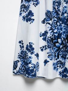 Gros plan détaillé de l'imprimé floral bleu et papillon sur satin blanc de luxe