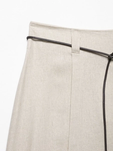 Detail of high-waist beige cotton linen skirt with texture and dark brown slim belt