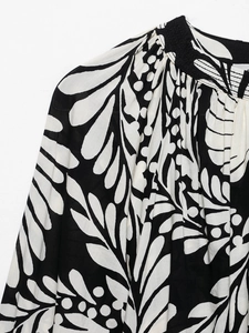 Detail of floral print top featuring elastic pleated collar and botanical leaf pattern