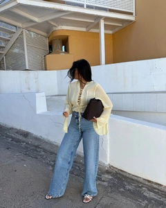 Detail of light yellow tie-front chiffon blouse paired with wide-leg blue jeans