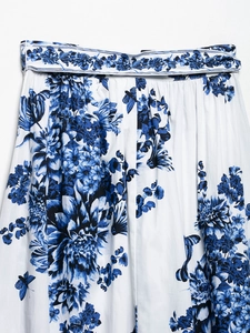 Gros plan détaillé d'une jupe midi en satin à fleurs bleues avec ceinture assortie