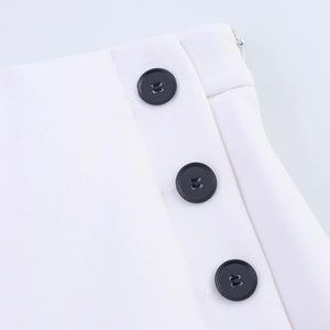 Close-up of white twill fabric with side black buttons and hidden zipper detail