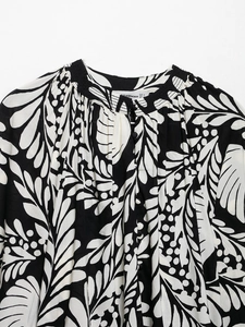 Detail of floral leaf print blouse featuring pleated collar and small round buttons