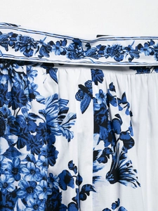 Vue détaillée de l'imprimé floral bleu et de la ceinture sur une jupe midi blanche